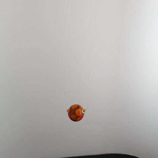 Collier une perle ronds oranges sur fond fumé